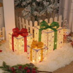 A Caixa de Presente Natalina Iluminada com Laço Decorativo é uma soma perfeita para trazer um charme festivo à sua decoração de Natal. Oriente conjunto, constituído por três caixas de presente iluminadas e adornadas com laços, é ideal para ser disposto sob a árvore ou em qualquer outro sítio, criando uma atmosfera acolhedora e mágica. As caixas são equipadas com luzes LED que oferecem vários modos de iluminação, todos controláveis por um prático controle remoto.